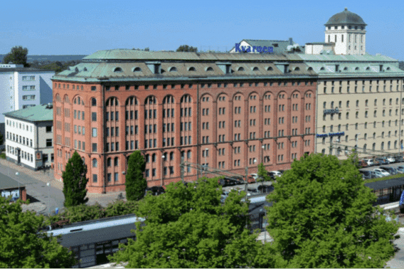 Historisk byggnad i centrala Kristianstad, omgiven av grönska och med tågstation i närheten